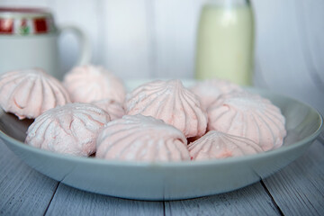 Pink marshmallows on a white plate. White and pink sweet homemade marshmallows or zephyr. Side view. Selective focus.