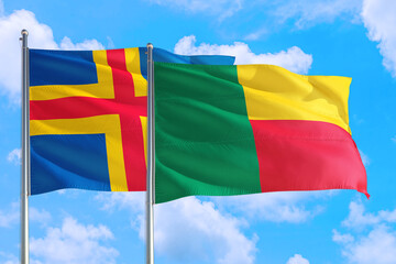 Benin and Aland Islands national flag waving in the windy deep blue sky. Diplomacy and international relations concept.