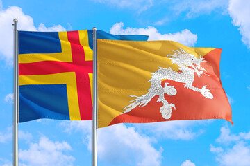 Bhutan and Aland Islands national flag waving in the windy deep blue sky. Diplomacy and...