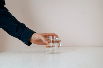 feeling thirsty in the early morning, person's hand taking a glass of water from the table