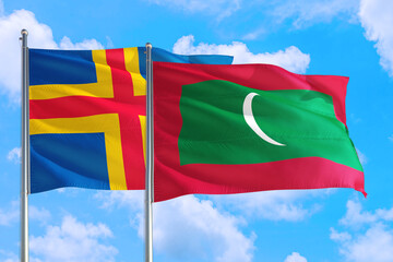 Maldives and Aland Islands national flag waving in the windy deep blue sky. Diplomacy and international relations concept.