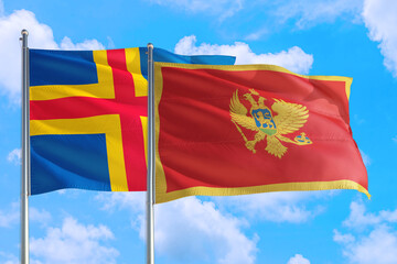Montenegro and Aland Islands national flag waving in the windy deep blue sky. Diplomacy and international relations concept.