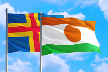 Niger and Aland Islands national flag waving in the windy deep blue sky. Diplomacy and...