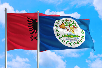Belize and Albania national flag waving in the windy deep blue sky. Diplomacy and international...