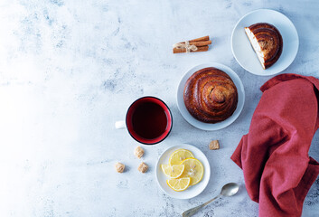 Winter Christmas holidays background with Cup of tea and wool scarf, cinnamon bun roll and snowman