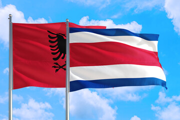 Fototapeta na wymiar Costa Rica and Albania national flag waving in the windy deep blue sky. Diplomacy and international relations concept.