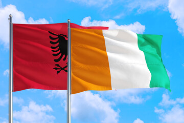 Cote D'Ivoire and Albania national flag waving in the windy deep blue sky. Diplomacy and international relations concept.