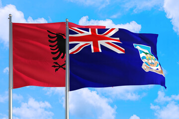 Falkland Islands and Albania national flag waving in the windy deep blue sky. Diplomacy and...