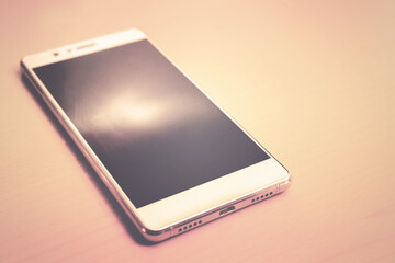 modern Smart Phone vintage effect, the object is on wooden background (soft retro style filter effect)
