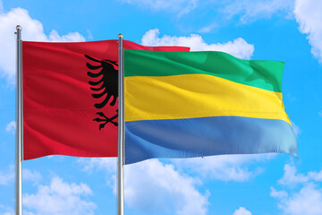 Gabon and Albania national flag waving in the windy deep blue sky. Diplomacy and international...