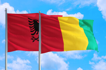 Guinea Bissau and Albania national flag waving in the windy deep blue sky. Diplomacy and international relations concept.
