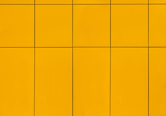 the wall of the house is covered with yellow ceramic tiles on the outside