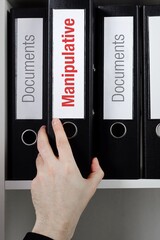 Manipulative. File Folder is taking by a hand from office shelf. Red Text is on the label of the...