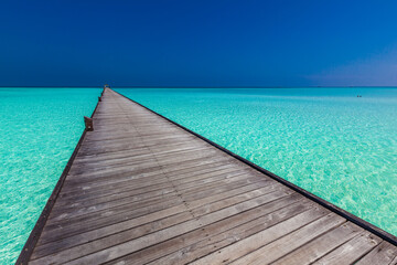 Obraz premium Jetty over atoll and a tropical resort island in Maldives