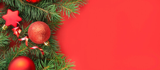 Red balls with fir branches on a red background. Festive Christmas decorations. Christmas background. Banner layout, postcard. Copy space.