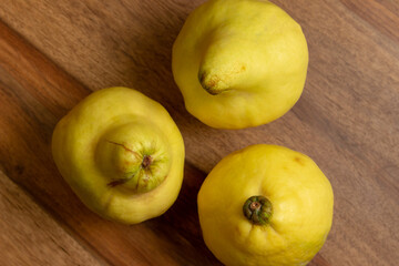 three ripe quinces on a table