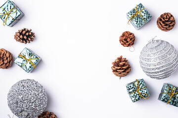 Christmas New Year composition. Gifts, fir tree cones, silver ball decorations on white background. Winter holidays concept. Flat lay, top view, copy space