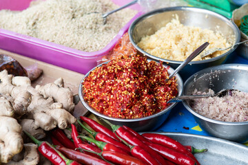 Fresh cut chili in metal bowl with other spices at market in Ho Chi Minh City. Select focus on center of frame. Asian spices.
