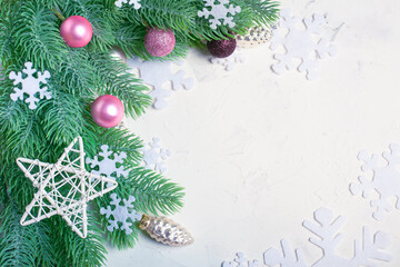 Happy New Year composition. Fir branches on white background. Christmas still life made of fir branches, white snowflakes and pink toys. Flat lay, top view, copy space.