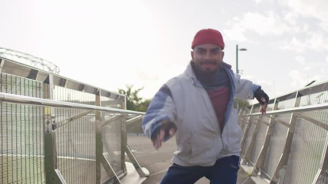 Young man dancing on roller skates towards the camera, in slow motion