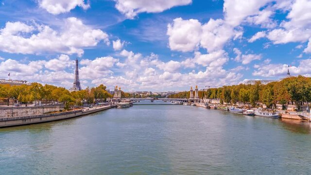 A timelapse of the Eiffel Tower along the river Seine with flyboats passing by with motion blur.Sunny but cloudy autumn day with golden yellow leaves,paris city riverside bay view bridge panorama