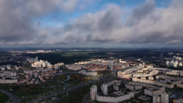 City district under the low clouds. City miniature. Tilt shift lens blur effect. Aerial downwards panoramic view of the town