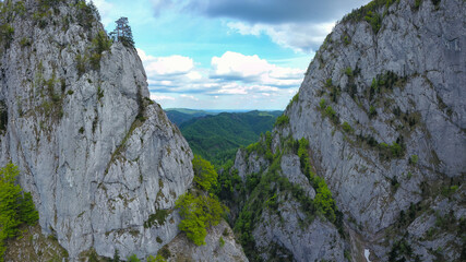 Aerial drone view of the abrupt and steep stone walls surrounding Cheia Gorges. Buila Vanturarita Massif, Carpathia, Romania