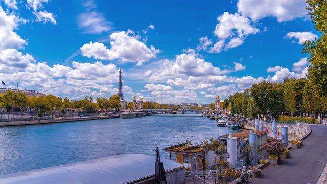 A timelapse of the Eiffel Tower along the river Seine with flyboats passing by with motion blur.Sunny but cloudy autumn day with golden yellow leaves,paris city riverside bay view bridge panorama
