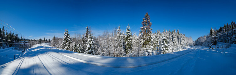 Railway through snowy fir forest and remote alpine helmet in Carpathian mountains, snow drifts  on wayside