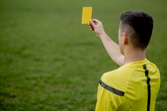 Referee showing a red card to a displeased football or soccer player while gaming. Concept of sport, rules violation, controversial issues, obstacles overcoming.