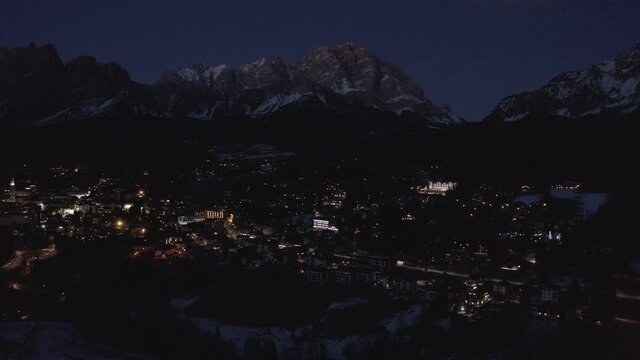 Aerial 4K Drone Night View of Cortina d'Ampezzo in the Dolomites, including Monte Antelao and Monte Cristallo on a crisp cold spring night