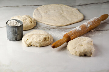 making pizza process, woman's hand working with dough and flour, white and grey background