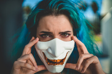 Portrait of a female with blue hair wearing a Halloween mask