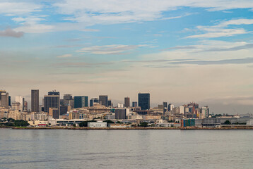 Obraz premium Rio de Janeiro, Brazil - December 22, 2008: Gray water of Guanabara bay with office towers skyline of downtown district under light blue cloudscape.