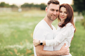 Obraz premium beautiful young couple hugging and having fun outdoors in the park on a warm summer sunny day
