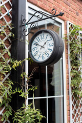 Fototapeta na wymiar Street clock on the wall. Arabic numerals