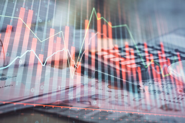 Double exposure of financial chart drawings and desk with open notebook background. Concept of forex market