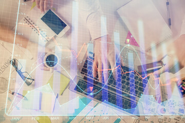 Multi exposure of man's hands typing over computer keyboard and forex graph hologram drawing. Top view. Financial markets concept.