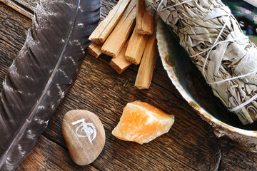 A top view image of white sage smudge stick with healing crystals, sacred feather and reiki symbol.