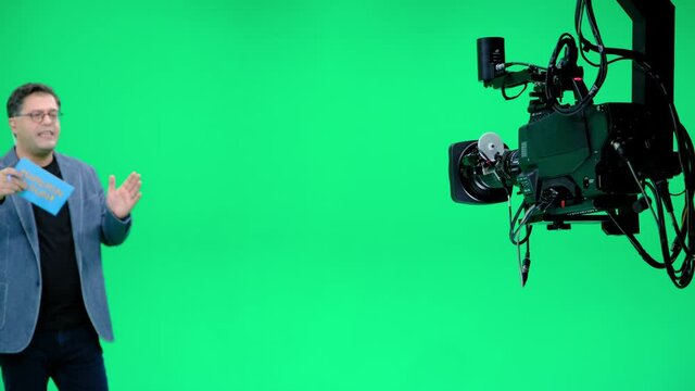 In a professional green screen studio, the camera jib shooting the television presenter. Film and Television Industry
