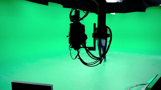 In a professional green screen studio, the camera jib shooting the television presenter. Film and Television Industry
