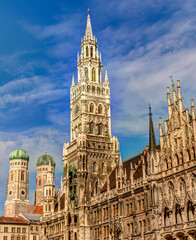 Fototapeta na wymiar Historic Munich town hall at the Marienplatz with a Frauenkirche in the background on a sunny day.