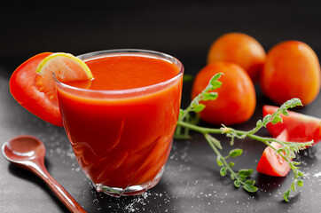 Tomato juice in glass with row tomato on wood background. fresh organic vegetables. healthy juice drinks concept.