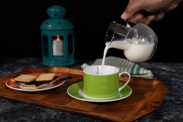 image of exquisite snack coffee, milk and cookies by candlelight