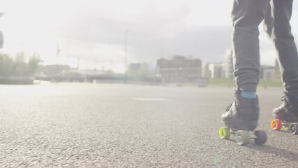 Camera follows the feet of a person in roller skates as they skate on wide open surface, in slow motion - Powered by Adobe