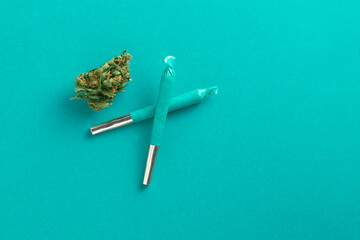 Cool blue cannabis joints overhead with marijuana bud. Winter or spring colour. - obrazy, fototapety, plakaty