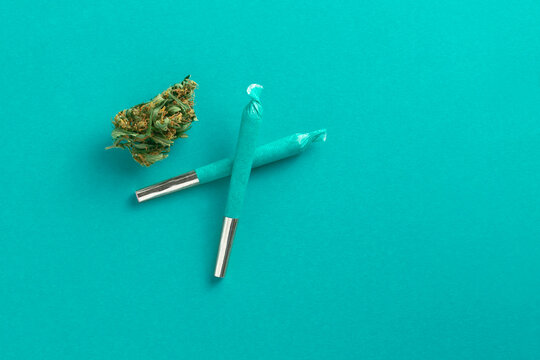 Cool blue cannabis joints overhead with marijuana bud. Winter or spring colour.