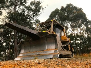 A bulldozer with a tree pusher attachment