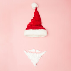 Christmas concert, New Year's hat and beard on a pink background, top view, copy space