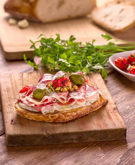 Traditional Italian bruschetta sandwich in slices of toasted baguette garnished with tomato, cheese and parma ham and olive oil.